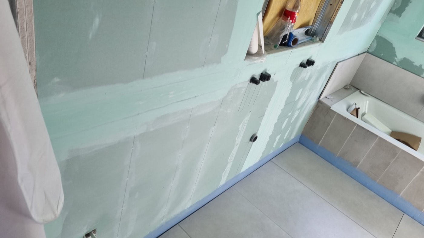 Badewanne im Rohbau mit Trockenbauwand und Anschlüssen