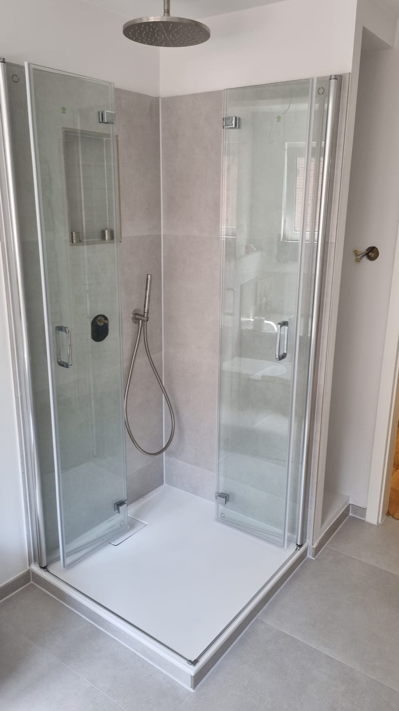 Ebenerdige Dusche mit Regenbrause und Glastüren